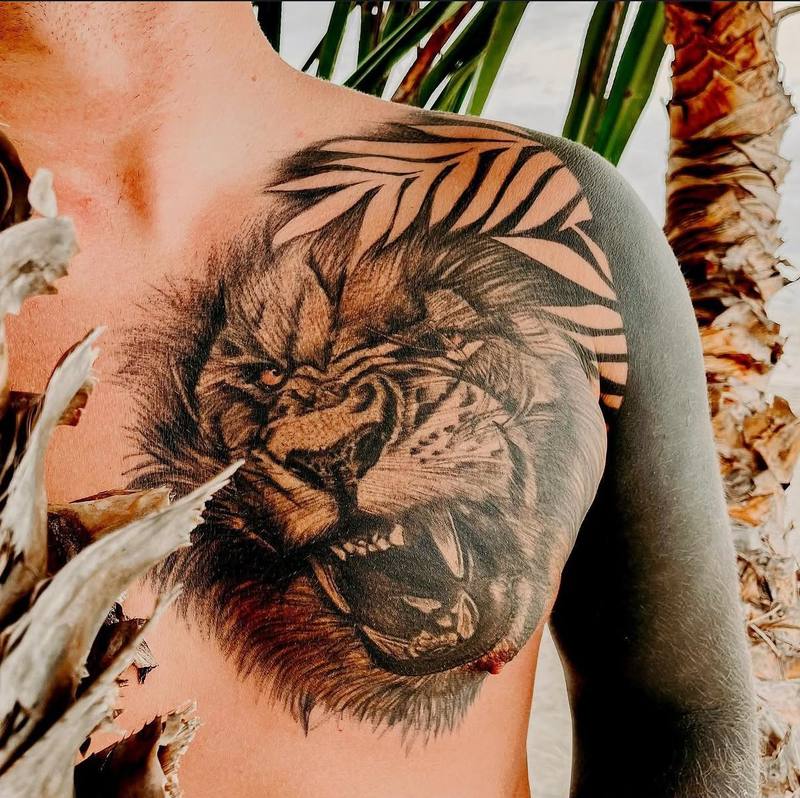 Löwenkopf-Tattoo mit geometrischen Linien auf der Schulter