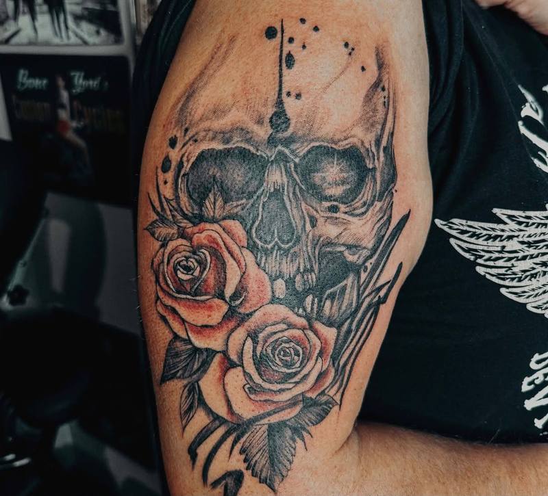 Totenkopf mit Rosen als Tattoo am Oberarm